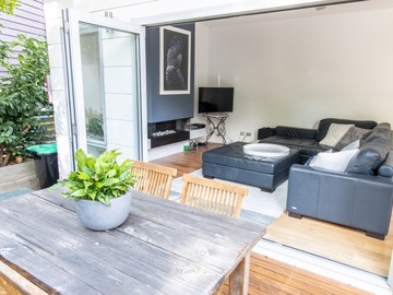 Renting out with online payment: Lounge area with fireplace opening to a spacious deck